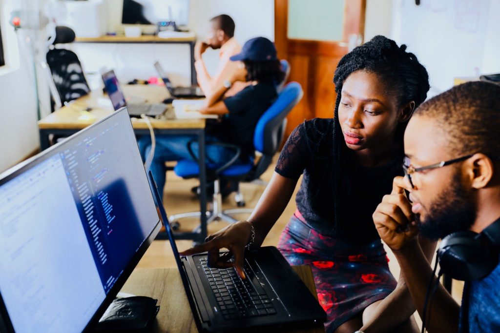 Women helping man with using a computer, strategic volunteering