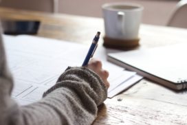 Hand holding a pen while writing, big five personality traits