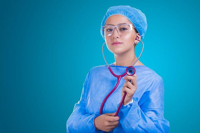 woman healthcare worker in scrubs holding stethoscope