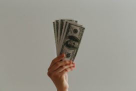Hand holding up money, salary research