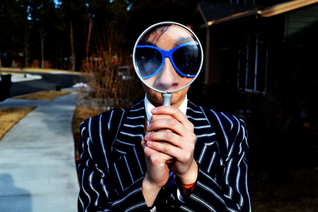 Person holding a magnifying glass to their face, résumé keywords