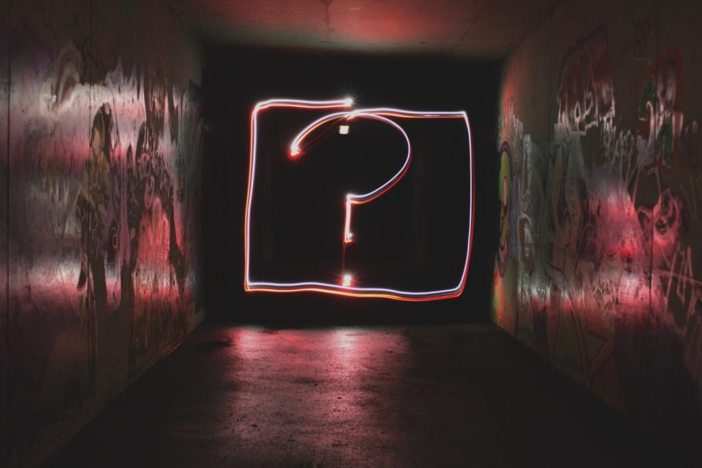 Pink light up question mark in front of a black background, most common job interview questions