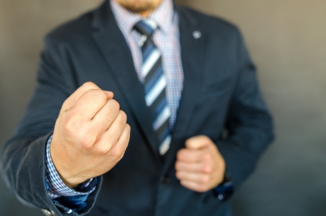 man in a suit with his fists up to fight