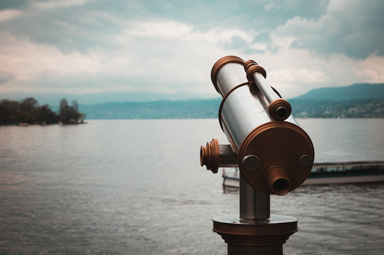 a telescope set up over Lake Zurich on a cloudy day