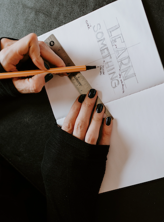 goth sketching "learn something" in their sketchbook