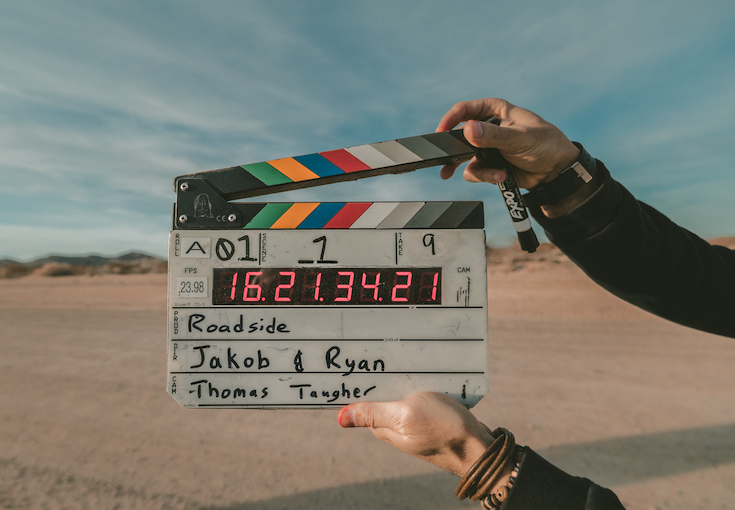 a movie clapper board on a roadside filming location