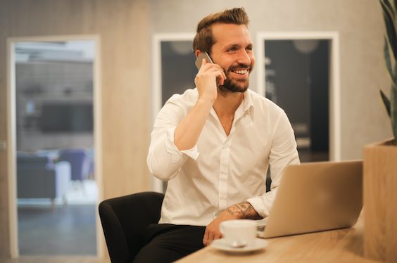 a consultant smiling on the phone and at his computer