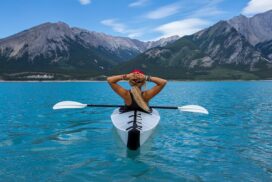 a woman relaxing in a kayak on a beautiful lake