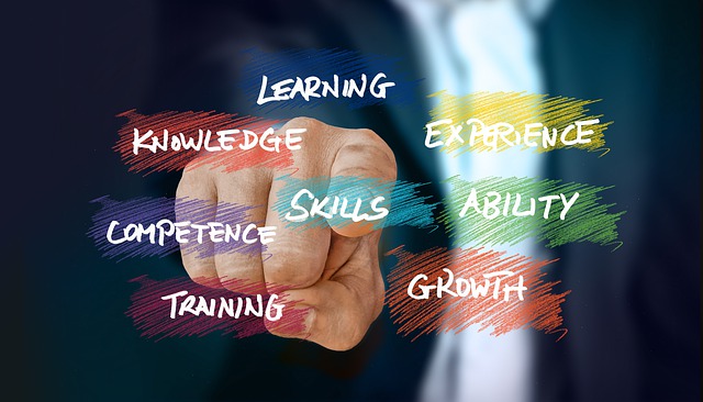 colorful job search words like skills training experience and competency with a hand, index finger pointing to them