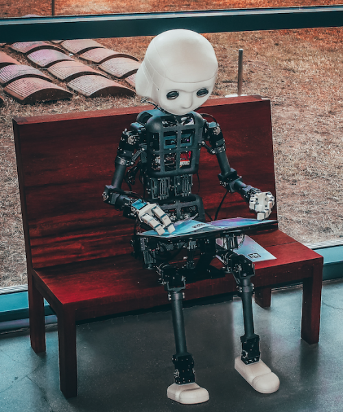 a robot sitting on a bench reading
