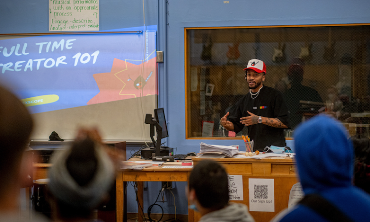 a creator 101 workshop in a classroom being led by a young Black trainer